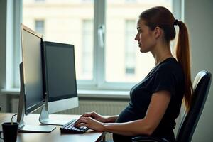 photo of pregnant woman working sitting at her desk in her office,