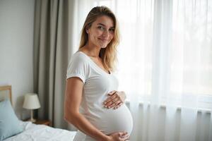 photo of pregnant woman with white curtain in background,