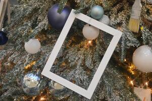 Christmas tree decorated with photo frame on fir branches, festive balls and decorations. New Year background.
