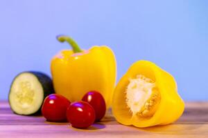 yellow bell peppers on wooden table, set of vegetables photo