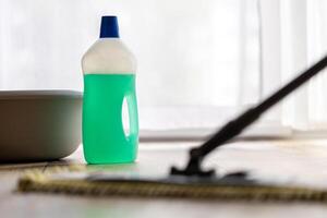 cleaning a wooden floor with a mop, cleaning agent bottle photo