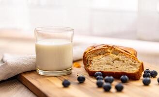 glass of milk and sweet homemade banana bread with crispy crust on a wooden board, dessert photo