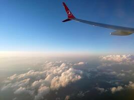 Antalya, Turkey, 2024 - Wing Of An Airplane Flying Above Morning Clouds photo