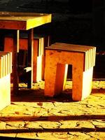 A yellow stool sitting and a table on the park with sunlight coming from the backside, creating calm and relax ambience photo