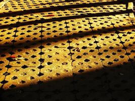Abstract background of a brick sidewalk with a shadow cast on it. Morning sunlight on the pathway. Beauty sunlight on the ground photo