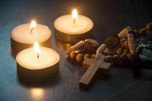 Holy Rosary with candles with customizable space for text. Copy space and Christianity concept. photo