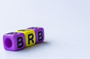 BRB text representing Be Right Back on small square toy on white background. Break time concept photo