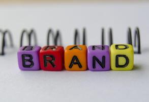 Close up of BRAND text representing on small square toy on white background photo