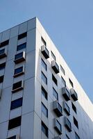 Modern white building with square windows. Multistory apartment building. Minimalistic Stylish living block of flats. Facades of modern office building. Exterior texture pattern. Visual art. Conceptual photo