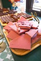 Wooden tray with magenta chocolate on a table at the event photo
