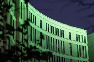 The business building in the form of a wave is illuminated late at night photo