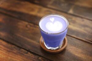 Glass mug with latte on wooden table photo