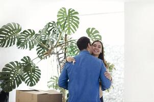 Happy couple with cardboard boxes hugging in new home photo