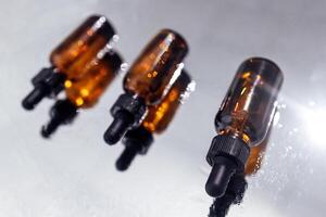 Group of bottles with drops on them and their reflection on a mirror surface photo