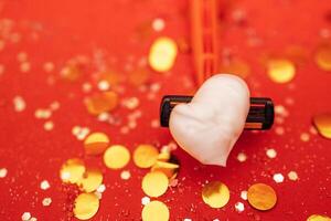 Razor with heart shaped shaving foam. Bright red background with silver glitters and gold round confetti. photo