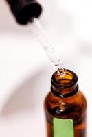 Close up of brown serum or oil glass with green stiker mock up on bottle on mirror background photo