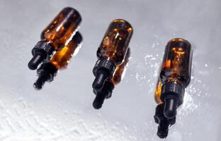 Group of bottles with drops on them and their reflection on a mirror surface photo
