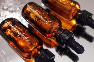 Group of bottles with drops on them and their reflection on a mirror surface photo