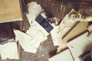 Retro background with vintage camera, case, old books, torn sheets of paper and a candle with melted wax drops. photo