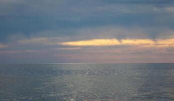 Seascape. Waves and surf. Sunset and dawn at sea. Calm on the ocean. Beautiful sky and clouds illuminated by the sun. Natural background. Summer time. photo