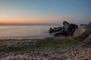Seascape. Waves and surf. Sunset and dawn at sea. Calm on the ocean. Beautiful sky and clouds illuminated by the sun. Natural background. Summer time. photo