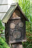House for insects. A box made of bark, straw and stones. Bricks, cones and bamboo for the insect to settle there. Home for wild bees. Eco friendly do-it-yourself craft. Idea for a garden. DIY photo
