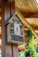 House for insects. A box made of bark, straw and stones. Bricks, cones and bamboo for the insect to settle there. Home for wild bees. Eco friendly do-it-yourself craft. Idea for a garden. DIY photo
