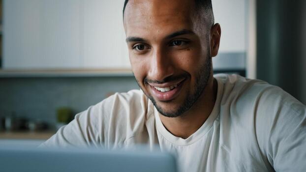 Close up front view African multiethnic man guy indoors using laptop typing chatting browsing with computer at home working remote play online game internet app shopping e-commerce website distant job photo