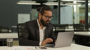 Upset worried shocked frustrated Indian businessman read terrible information problem trouble error unsaved report on laptop computer in office lost failure sad business man stressed reading bad news photo
