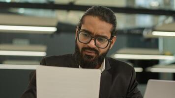 Arabian Muslim business man Indian businessman employer entrepreneur manager confused with papers and laptop in office problem paperwork bad result talking call working with documents failure photo
