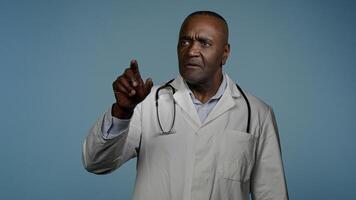 Focused african american man doctor male professional medical worker healthcare employee in blue studio move hands in air imitating work on 3D hologram diagnostics using modern innovative technology photo