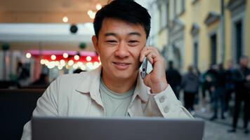 Man talking on phone looking at laptop screen male tourist client making order in online store remotely booking ticket on Internet businessman freelancer discussing business issues using telephone photo
