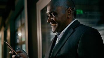 Happy smiling mature man holding phone browsing email writing text message uses mobile application satisfied businessman communicates with client on internet talking on call using smartphone photo