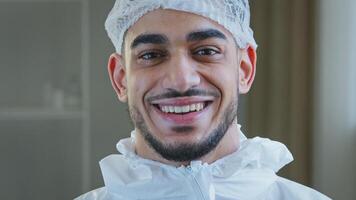 Smiling doctor arabic surgeon hispanic nurse medical worker in special uniform hat looks at camera smile toothy after successful operation working with coronavirus enjoying end of covid-19 pandemic photo