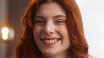 Attractive happy Caucasian woman close up carefree female pretty lady look at camera winking playful gesture joy emotion sign blink charming redhead girl smile with perfect white teeth posing at home photo
