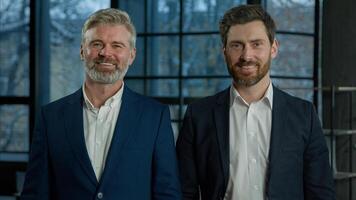 Portrait successful smiling Caucasian men businessmen business partners colleagues corporate leaders managers employees looking at camera posing indoors in office confident professional businesspeople photo
