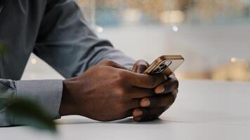 Close-up male hands typing on mobile phone unrecognizable african american businessman checking email working remotely using smartphone young man making order in online store browsing social network photo