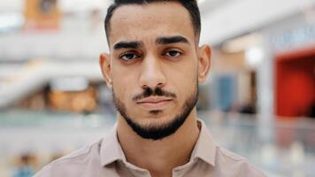 Close-up portrait male stressed face upset man sad frustrated millennial guy looking at camera serious Hispanic worker having negative thoughts difficult trouble misunderstanding problems sadness photo