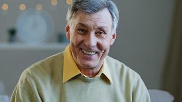 Happy elderly middle aged man make call recording vlog remotely communicate in online chat senior 60s grandpa smiling wave hand looking at camera caucasian old male enjoying distant talk at home photo