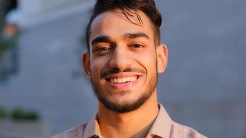 Moving camera hispanic business man happy arabian bearded guy satisfied cheerful carefree model smiling toothy looking at camera with friendly expression face in city, smile client dental service photo