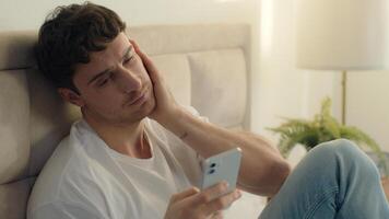 Caucasian European man bed using mobile phone smartphone error broken failure telephone gadget technology guy male notification displeased problem spam internet mistake social networks connect bedroom photo