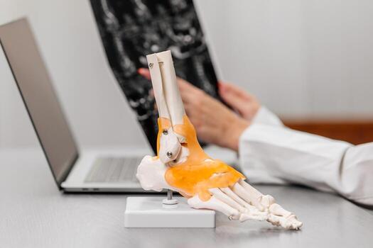 A doctor in a white coat provides expert advice on ankle joint conditions, using a detailed model for clear patient understanding. Perfect for medical consultations and educational content photo