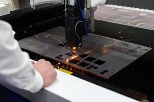 Cnc milling machine. The engineer is keeping an eye on processing and laser cutting for metal in the industrial photo