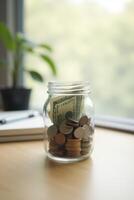 Jar of coins and dollar bill on desk, finance, savings or management money, investment concept with copy space photo