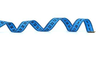 Blue measuring tape curled on white background representing fitness and precision photo