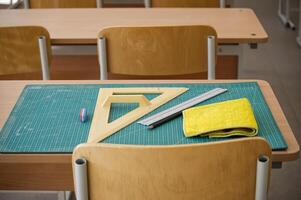 Classroom desk with math tools, ruler, and eraser on a cutting mat photo
