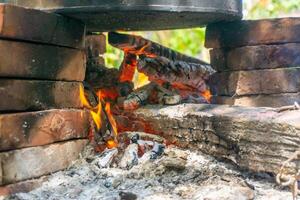 Asian traditional method of cooking. Boiling food with steam boiler and using fire woods. photo