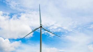 Wind Turbine Against Blue Sky with Clouds Generating Renewable Energy on a Clear Day photo