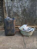 a bucket and a trash can sitting on the ground photo