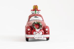 Christmas isolated red car with a wreath and gifts on a white background. photo